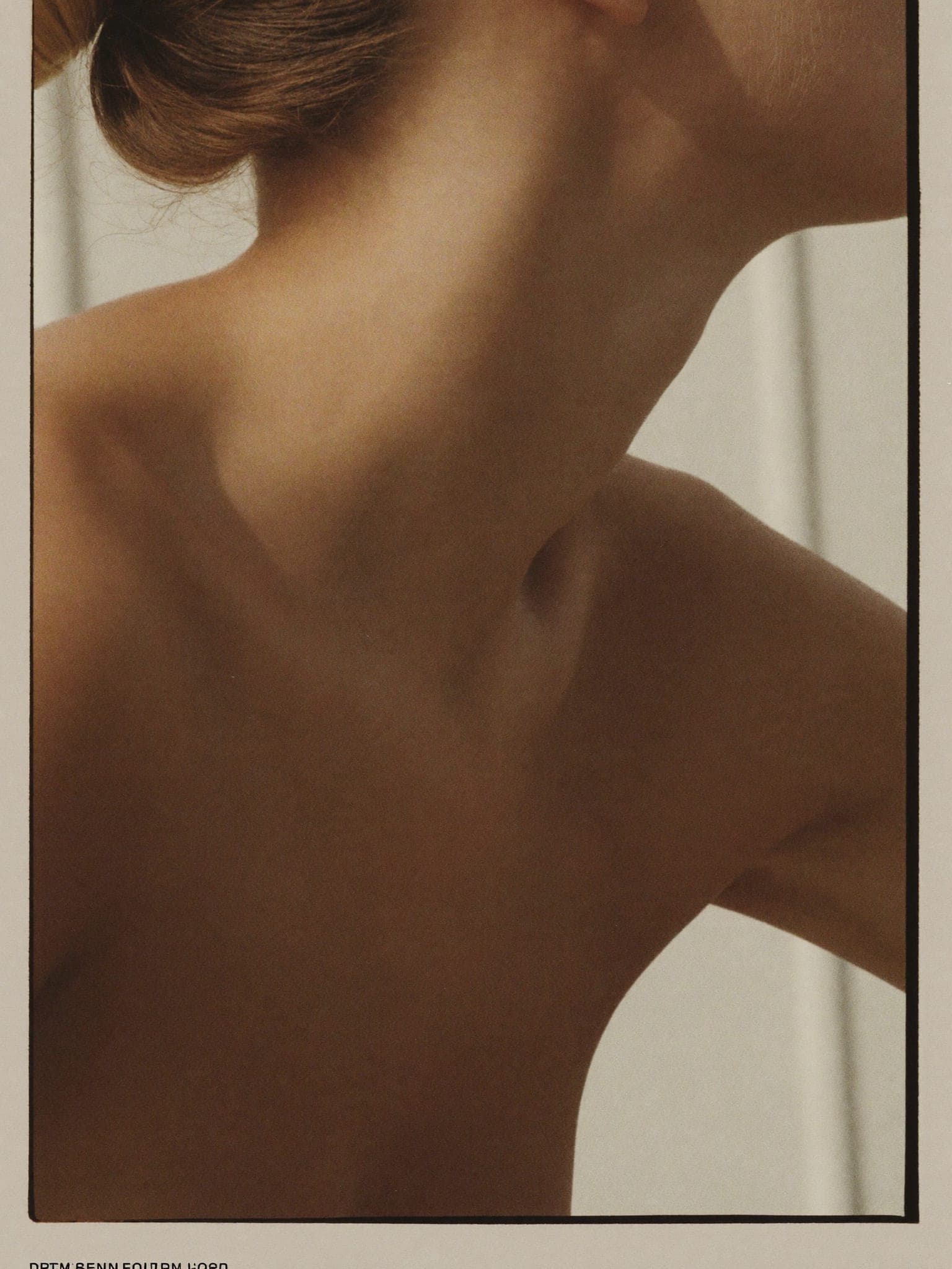 A profile view of a jawline and neck turned away from the camera in soft daylight